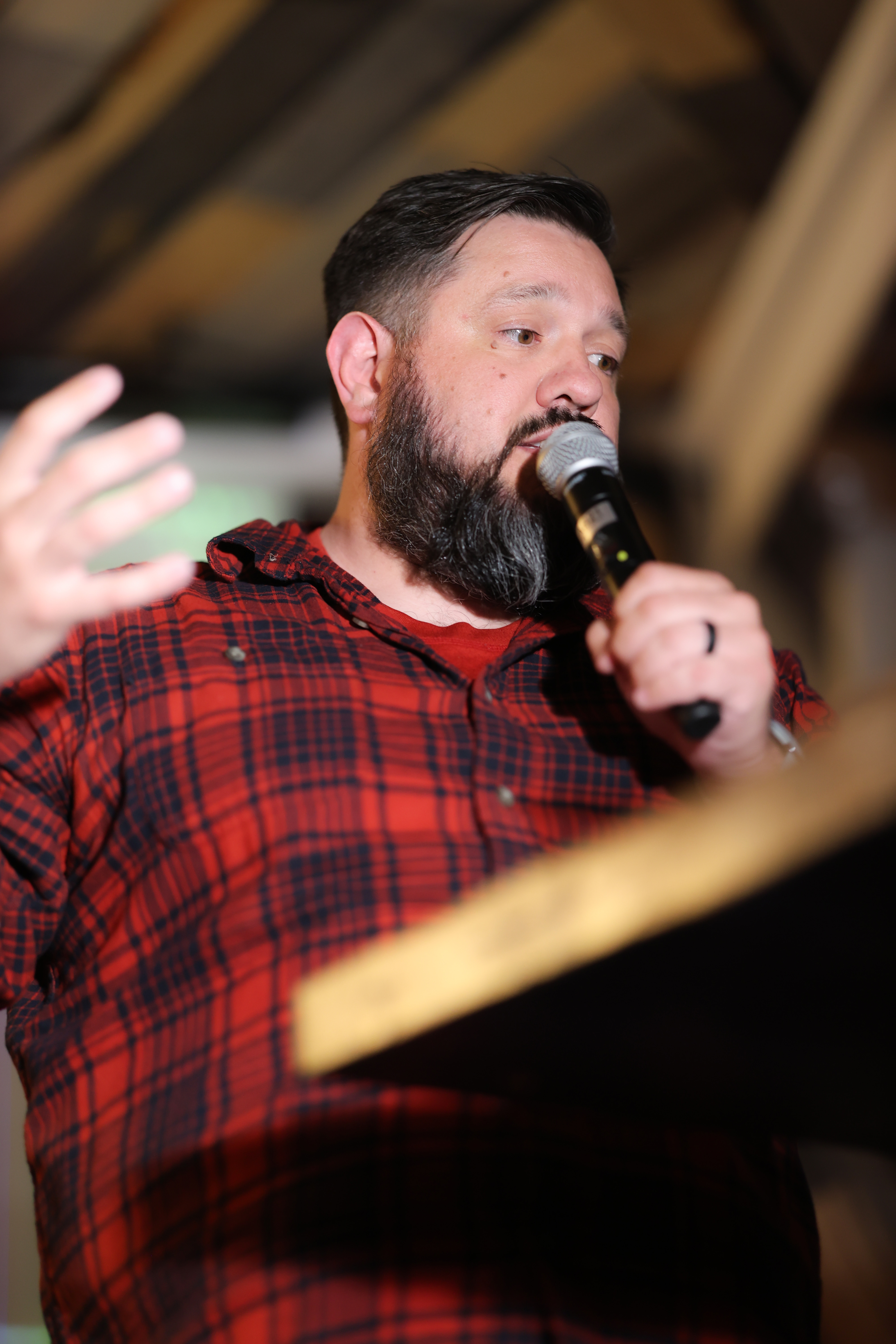 A close-up of Rob Edwards speaking passionately into a microphone, gesturing with his hand as he explains the ClassVibe AI multi-agent architecture to the crowd